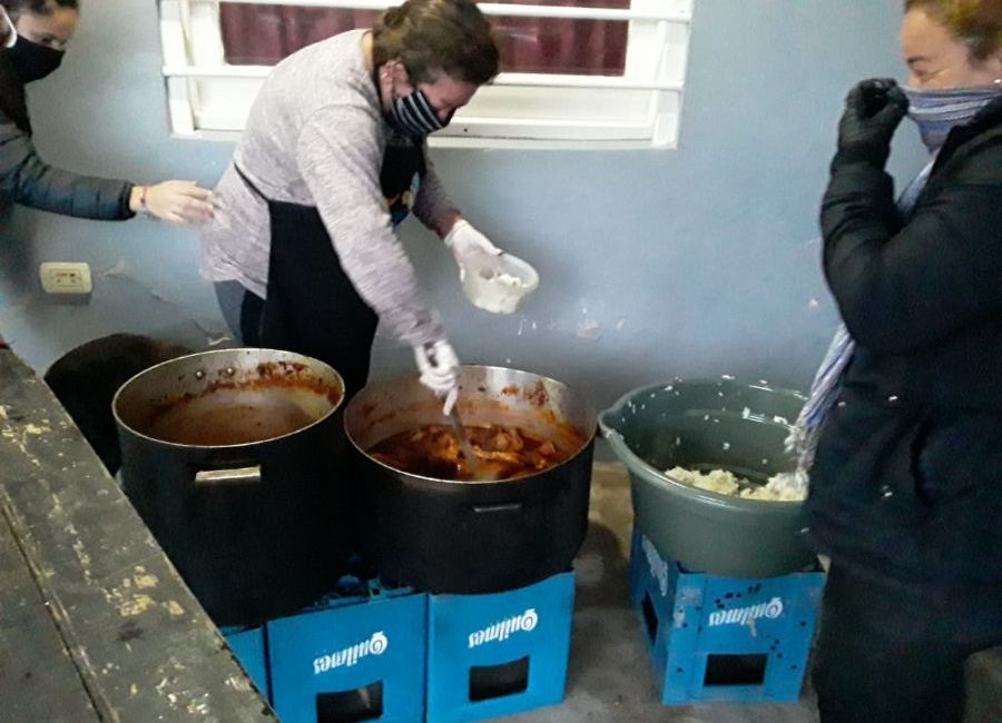 Las militantes reparten el locro.